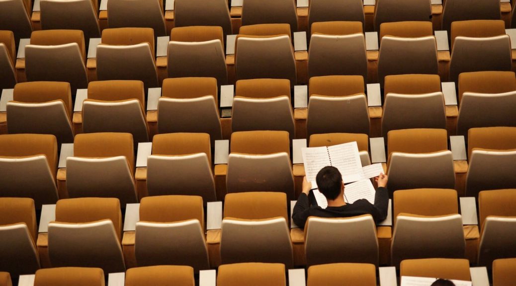 Estudiante estudiando solo en un auditorio.